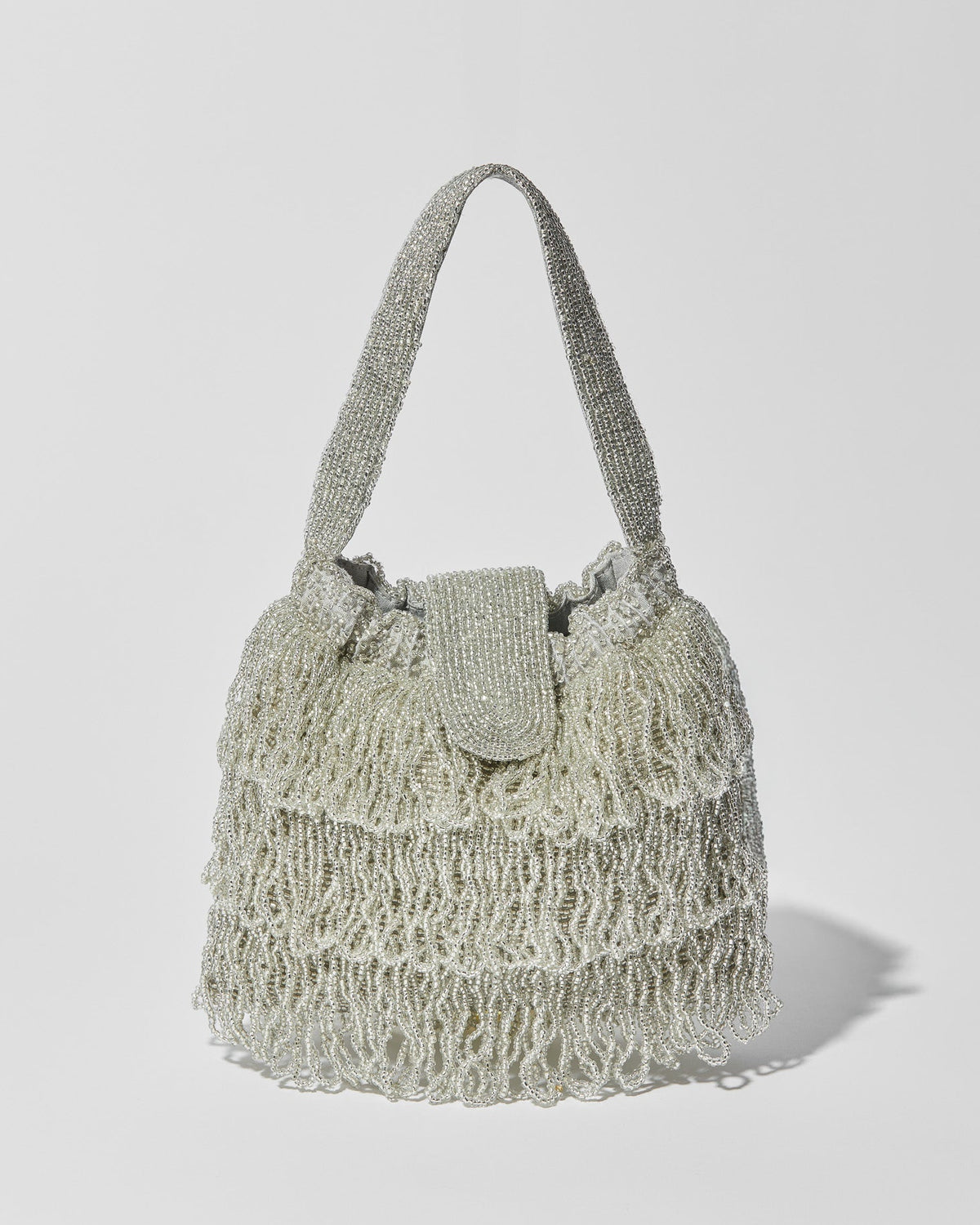 Silver beaded Tassel bag with layered fringe, top strap and beaded flap closure. Front view.