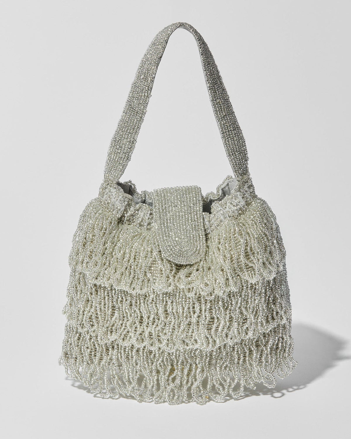 Silver beaded Tassel bag with layered fringe, top strap and beaded flap closure. Front view.