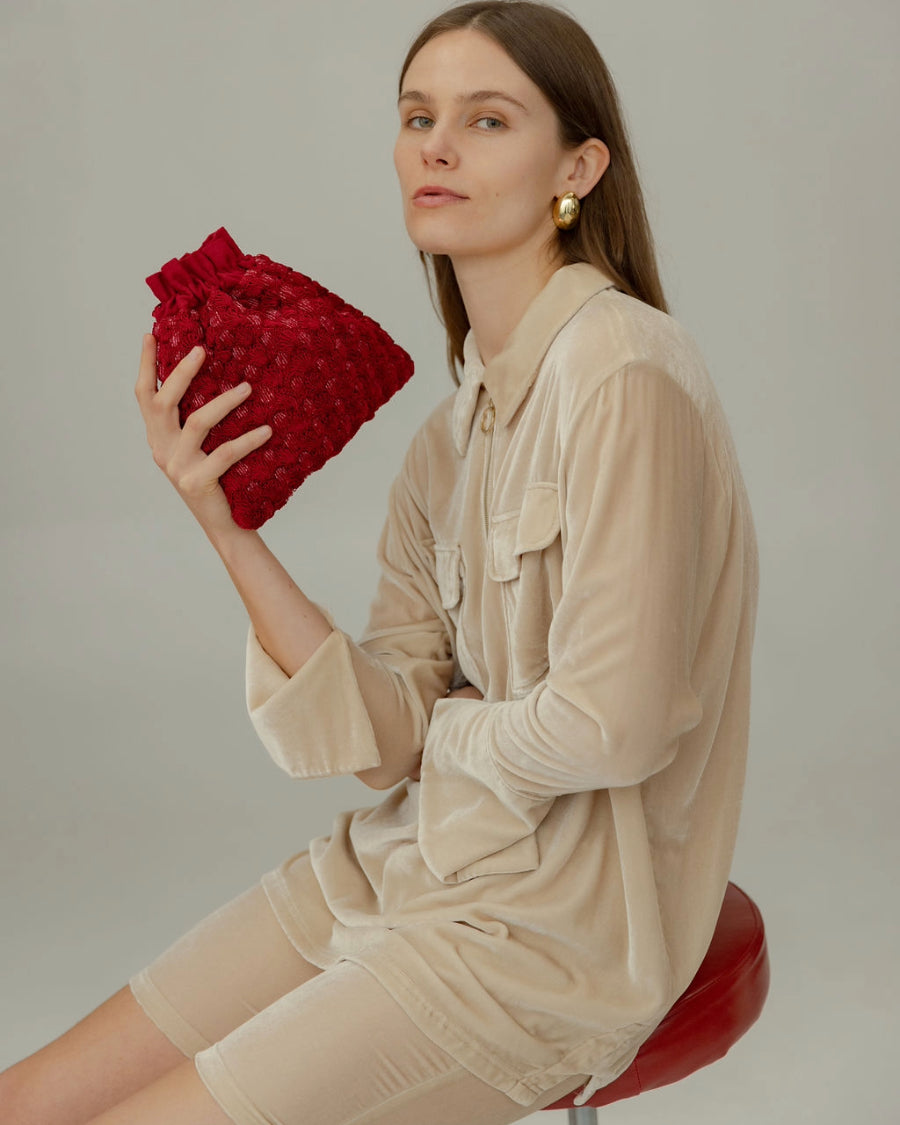 Model wearing the red beaded pouch over the shoulder, demonstrating its versatility for daytime or event wear.