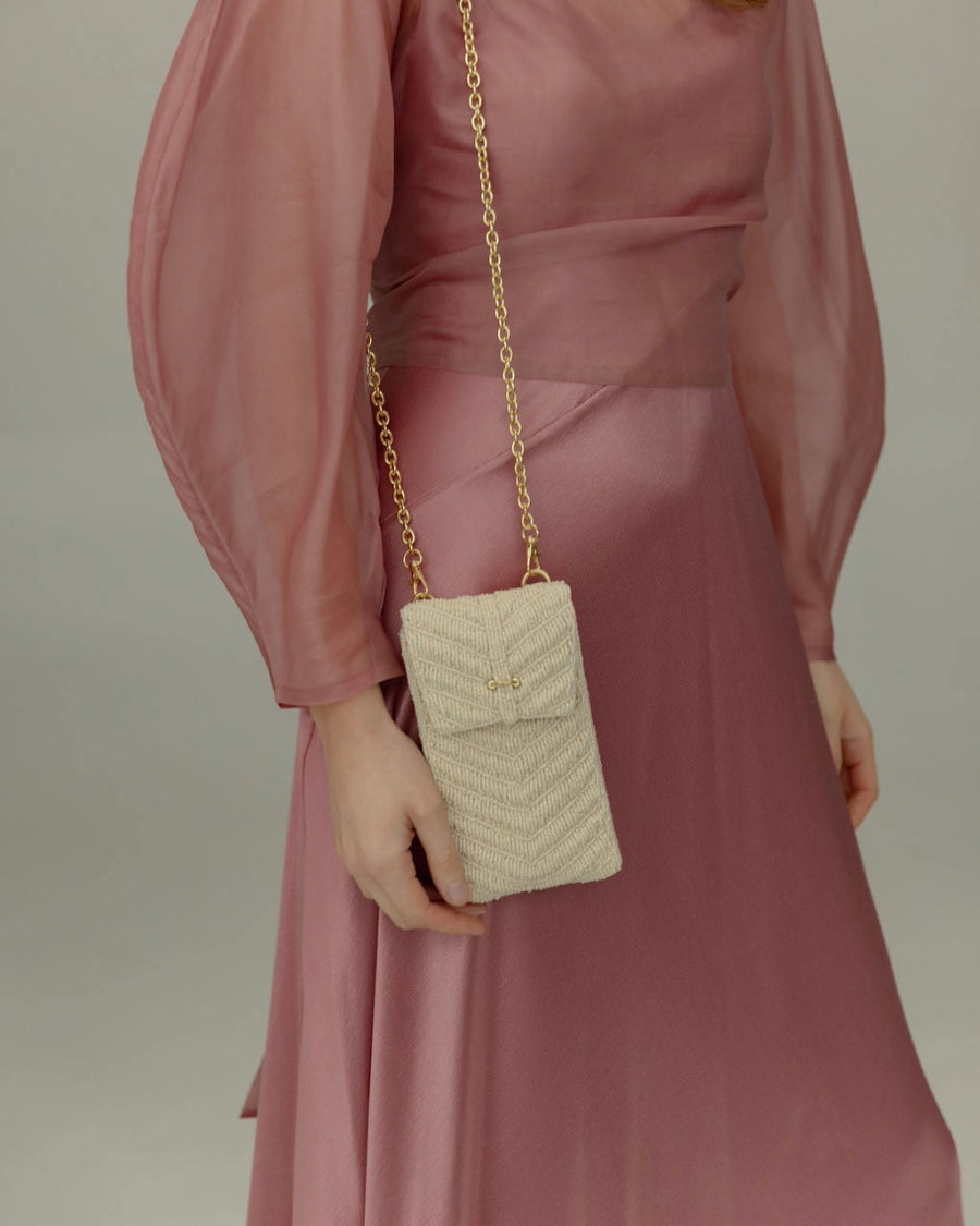 Close-up of the white beaded mini bag worn over the shoulder with its adjustable jute strap for a refined, natural daytime look.