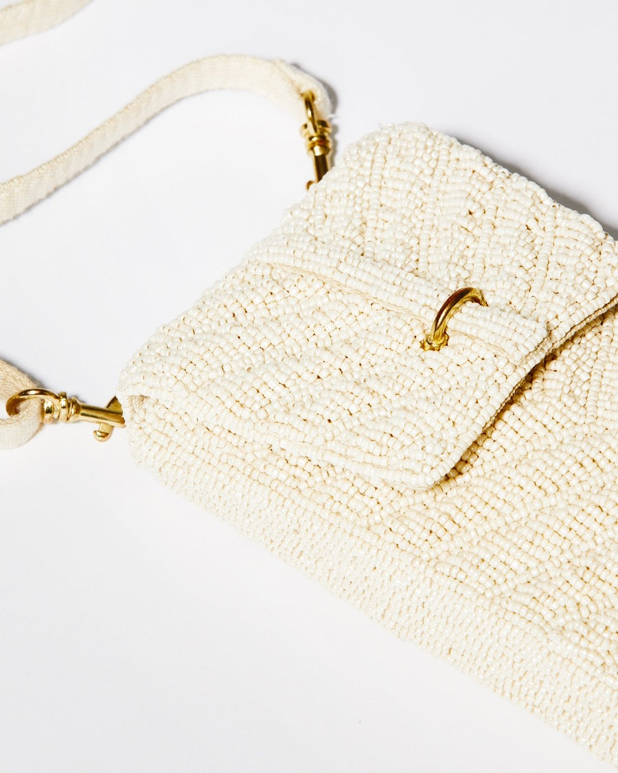 High-angle close-up of the downward chevron beaded pattern on the white Graceful Cascades mini bag, illustrating the skilled craftsmanship.