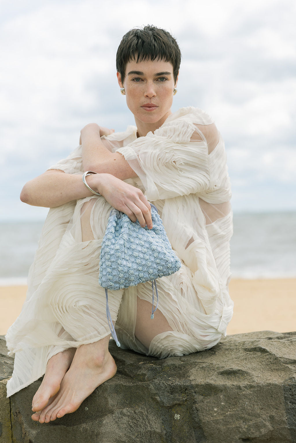 Model holding His Eyes blue beaded bag, evening occasion handbag