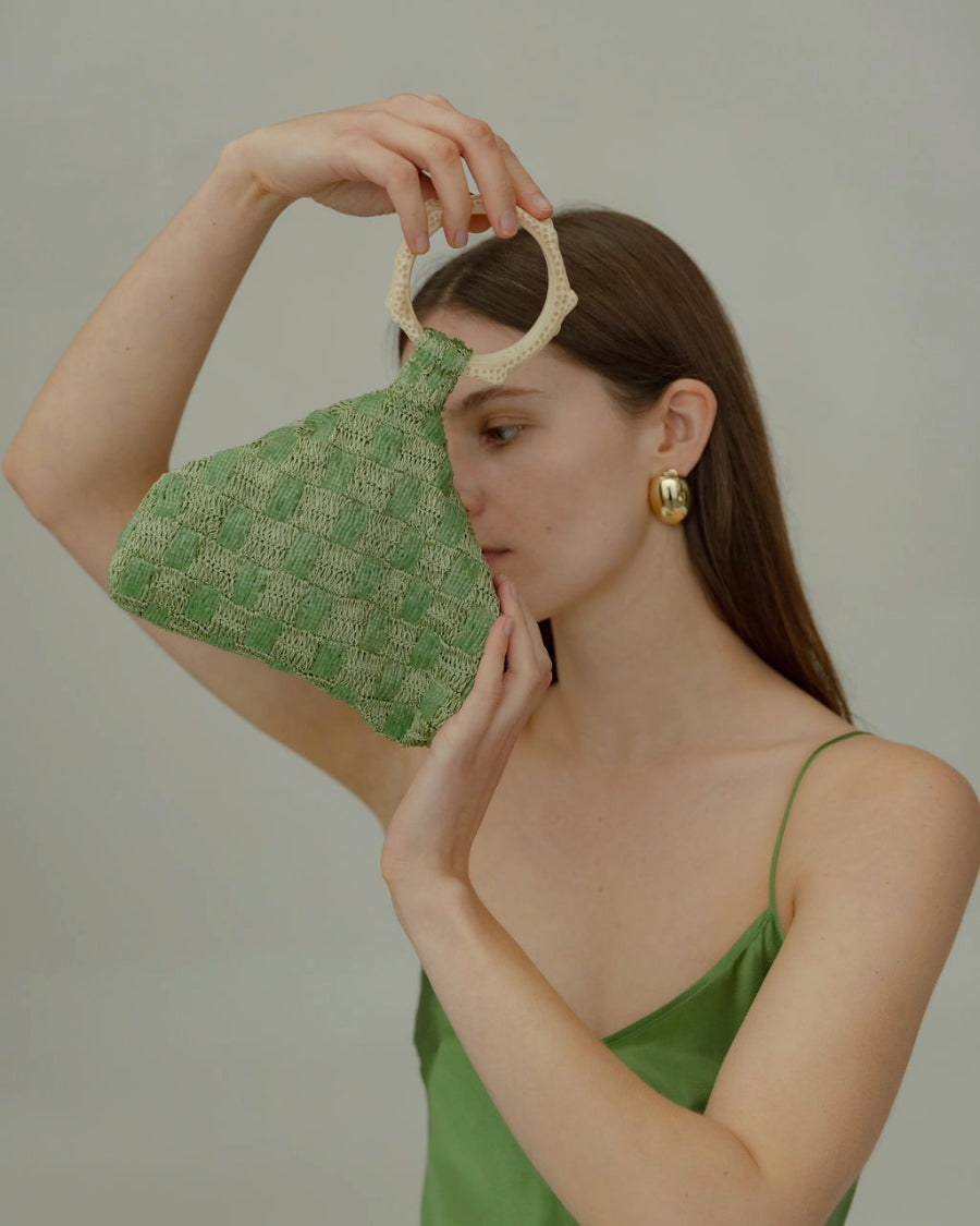 Intimate Exchange sage beaded bag in hand close-up of shape and sculpted silhouette