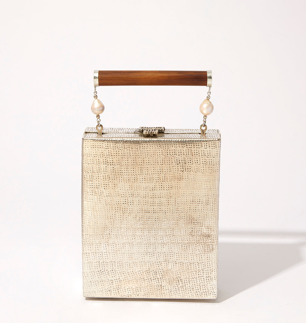 Straight-on view of the Modern World brass bag, illustrating its ability to function as both a handbag and a beautiful home ornament.