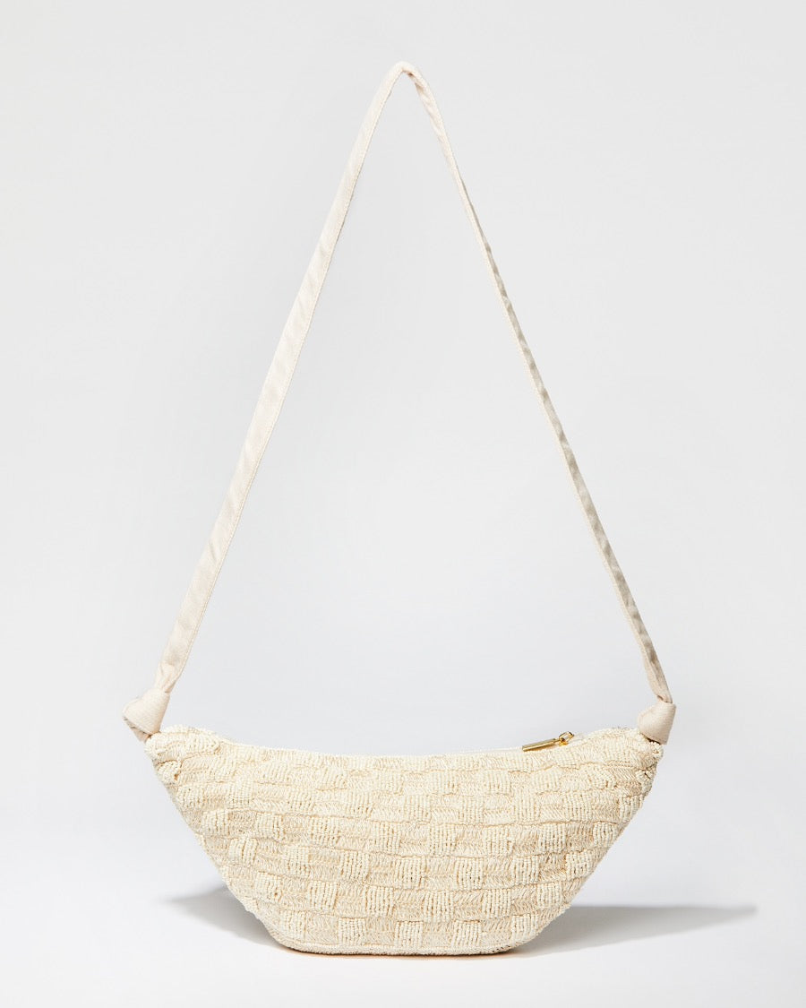 Front studio view of the Moving Through cream beaded bag featuring a sculptural curved silhouette and handcrafted beaded crochet texture.