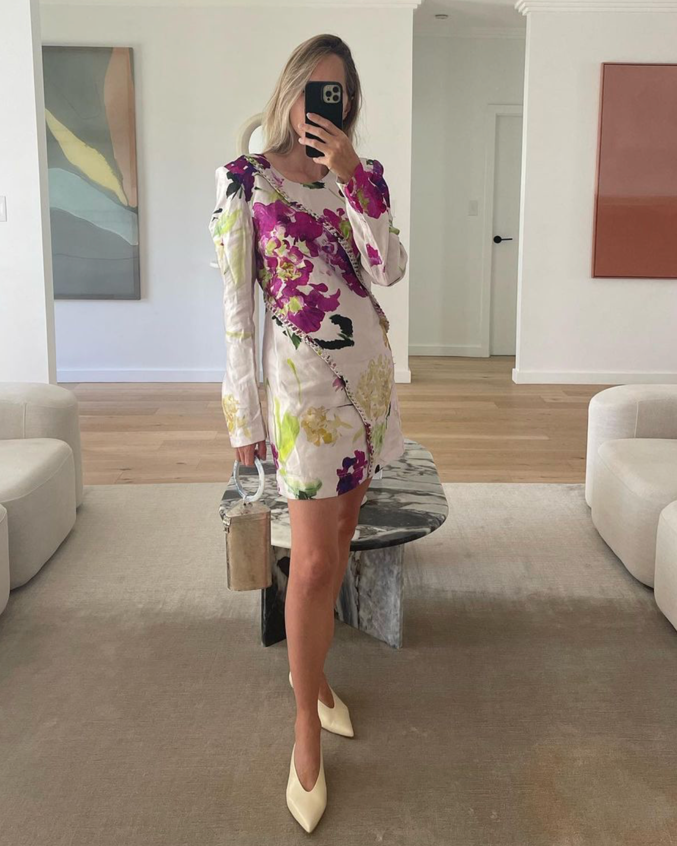 Mirror selfie of a women in a floral dress styling the brass Right Off The Edge bag.