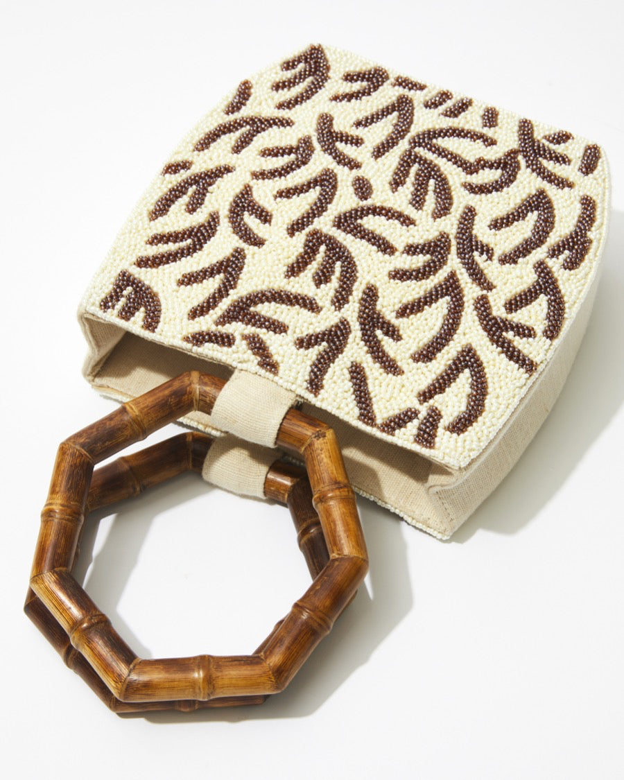 Front view of the Symbolic Path bag highlighting the intricate hand-dyed glass beads and the artisan-crafted embossed leaf design.