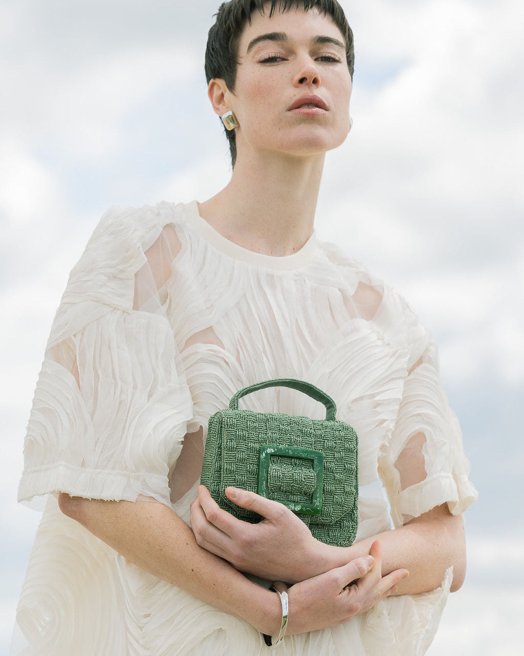 Model holding the jade green Uncovered Layers beaded bag, showcasing its vibrant colour and hand-dyed glass bead texture.