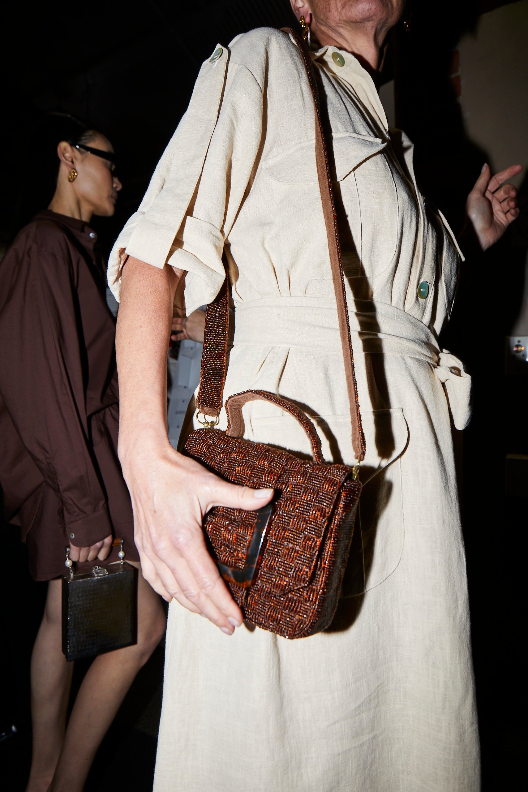 Candid lifestyle shot of the rich brown Uncovered Layers bag being worn as a crossbody, highlighting its wearable, everyday appeal.