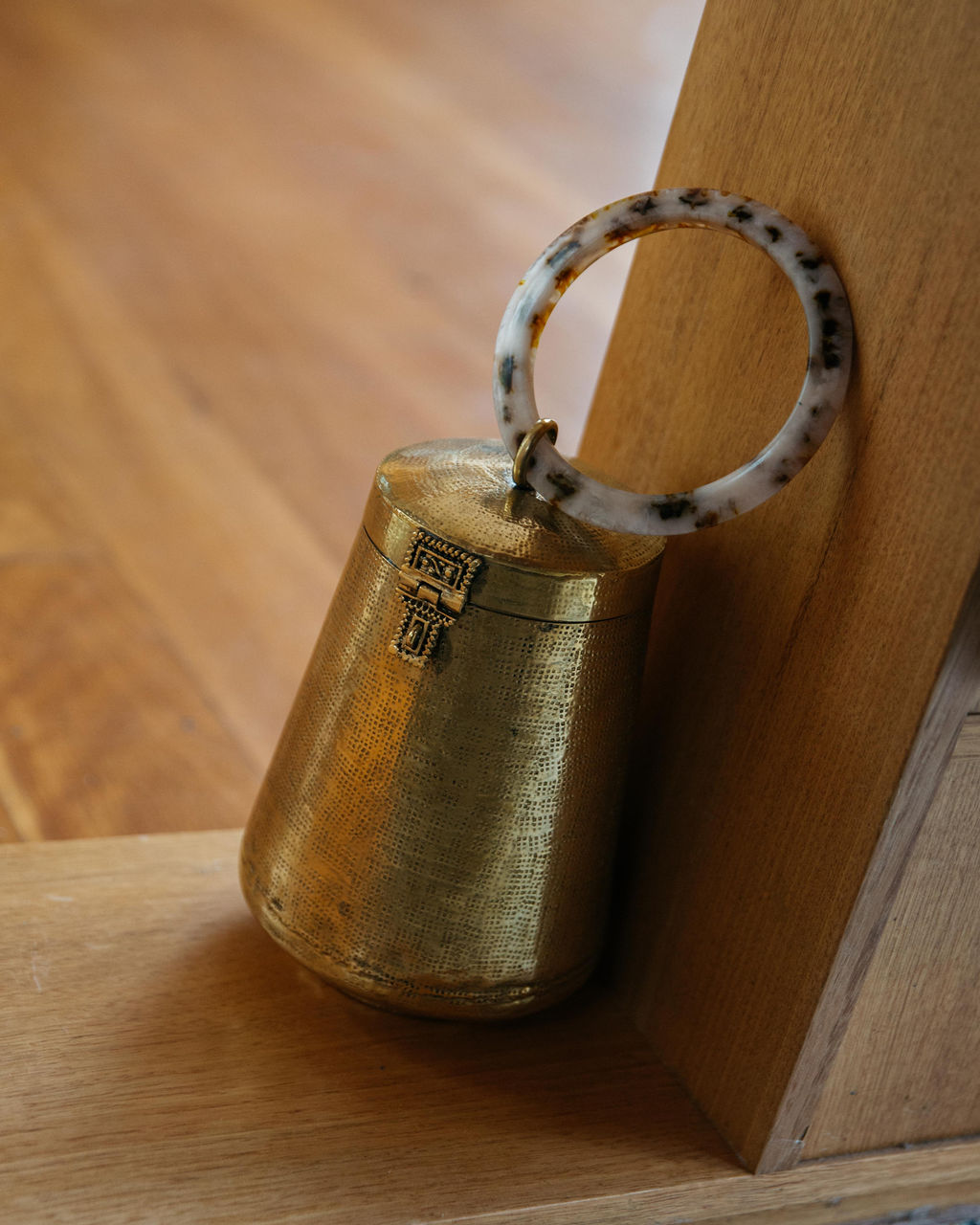 The Perception of Time gold bag displayed as a sculptural ornament on a wooden shelf, illustrating its dual-purpose design.