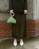 Green beaded handbag with woven check design and sculptural ivory top handle by The Hold.