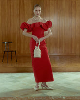 Model in red dress, holding ivory evening pouch with fringe tassels 