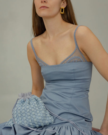 His eyes blue beaded bag sitting on model  lap styled with event dress