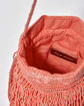 inside view of  coral tassel beaded bag featuring gathered drawstring top and long braided strap by the hold 