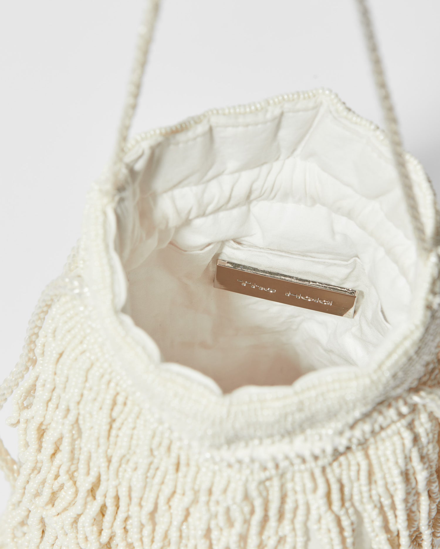 inside-viewIvory beaded fringe crossbody bag , gathered drawstring top and braided shoulder strap.