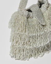 Silver beaded Tassel bag with layered fringe and beaded flap closure close up view.