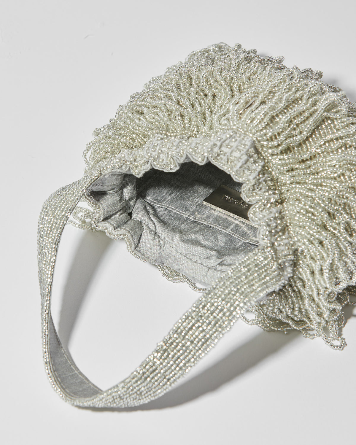 internal view of Mira Silver beaded Tassel bag with layered fringe top strap by the hold 