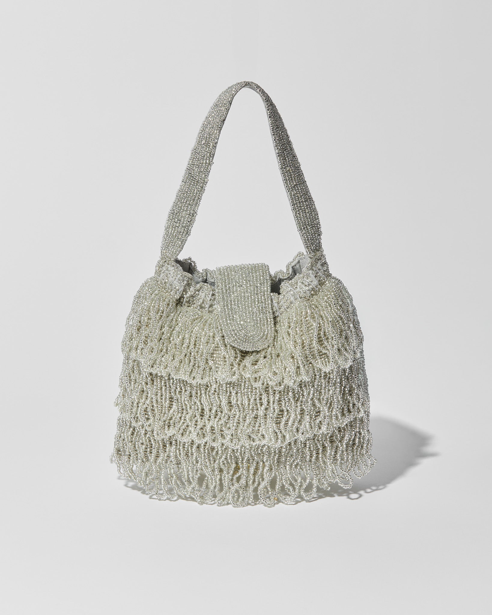 Silver beaded Tassel bag with layered fringe, top strap and beaded flap closure. Front view.