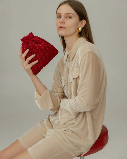 Model wearing the red beaded pouch over the shoulder, demonstrating its versatility for daytime or event wear.