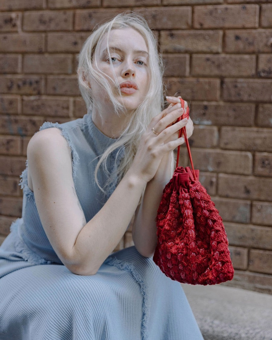 Candid portrait of a model holding the As Always pouch, emphasising its role as a statement accessory for special occasions.