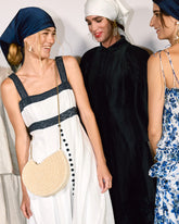 A group of women in Melbourne Fashion Week event attire, with one holding the Beyond Us beaded clutch, showcasing its sophisticated ivory hand-dyed beads.