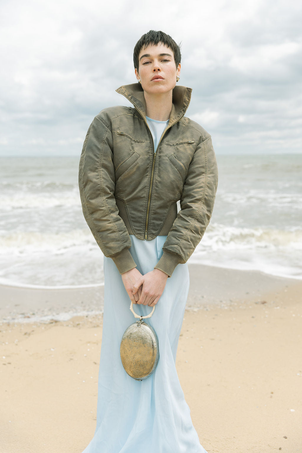 Full-length view of a model carrying the silver Capacity for Presence bag, demonstrating its elegant scale and artistic presence for special celebrations.