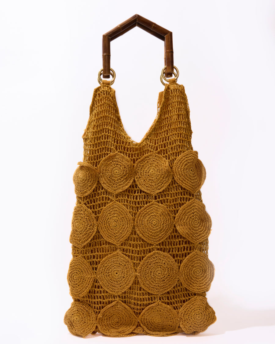 Full studio view of the Enveloped Tote in ochre, featuring handcrafted crochet circles and geometric bamboo top handles.