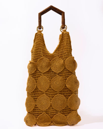Full studio view of the Enveloped Tote in ochre, featuring handcrafted crochet circles and geometric bamboo top handles.