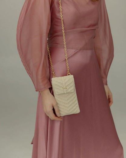 Close-up of the white beaded mini bag worn over the shoulder with its adjustable jute strap for a refined, natural daytime look.