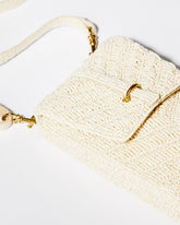 High-angle close-up of the downward chevron beaded pattern on the white Graceful Cascades mini bag, illustrating the skilled craftsmanship.