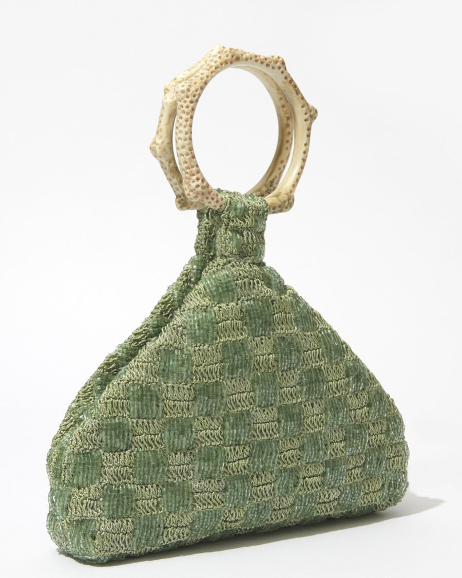 Intimate Exchange sage beaded handbag angled studio view with coral handle detail