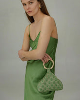 Model holding Intimate Exchange bag in sage green, beaded occasion bag for events