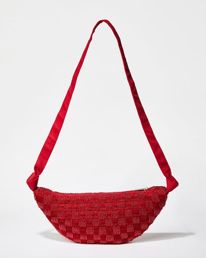 Front studio view of the Moving Through red beaded bag featuring a sculptural curved silhouette and handcrafted beaded crochet texture.