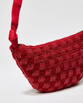 Close-up angled view of the red beaded bag showing the secure gold zipper closure and the slim 2cm depth of the sculptural form.