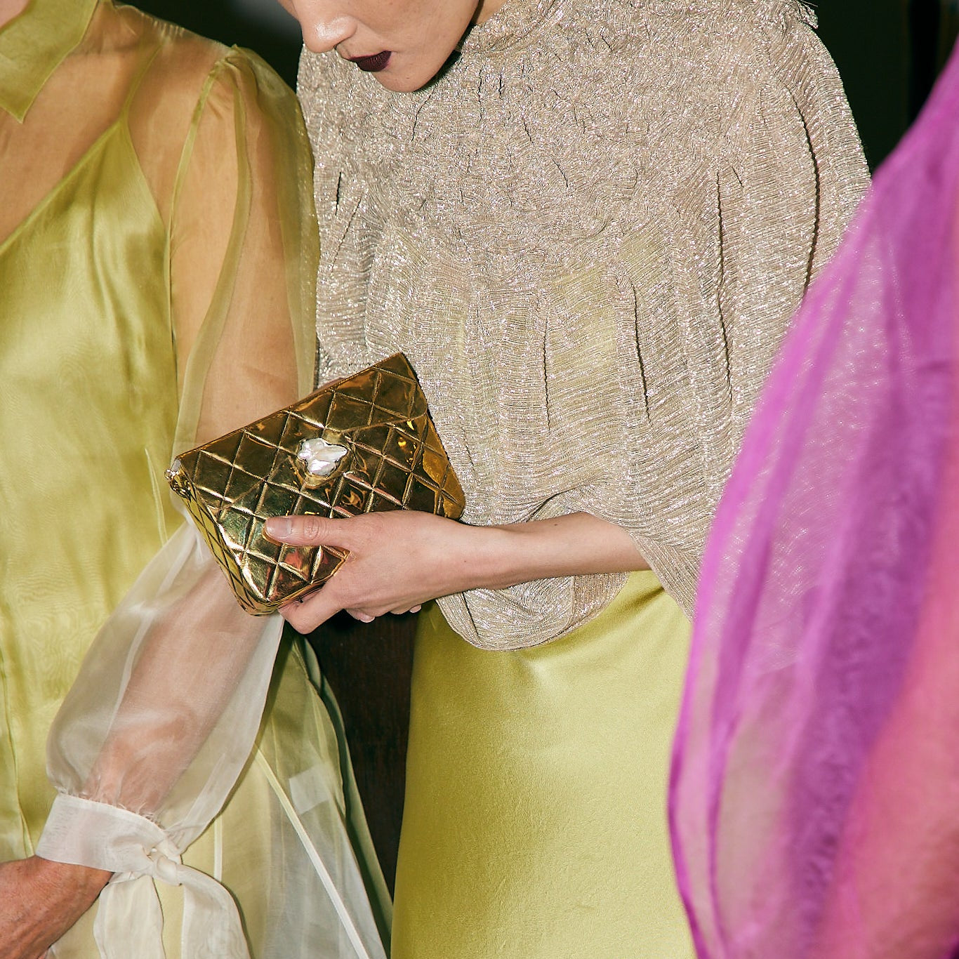 Candid lifestyle view of the gold metal bag paired with an elegant silk dress, perfect for weddings and special celebrations