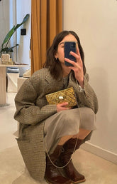 Mirror selfie of the gold Our Longing bag styled with a neutral knit, demonstrating its scale and 17cm width.