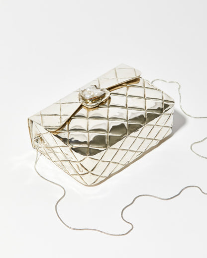 High-angle view of the silver metal bag showing the intricate individually shaped shell clasp and the high-shine quilted metal finish.