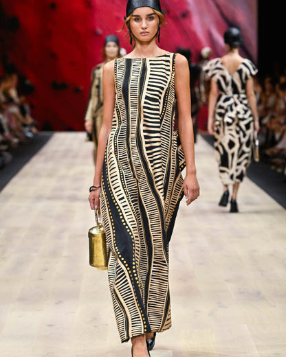 Model styling the Perception of Time gold bag on a fashion runway, showcasing its striking presence as a piece of wearable art.