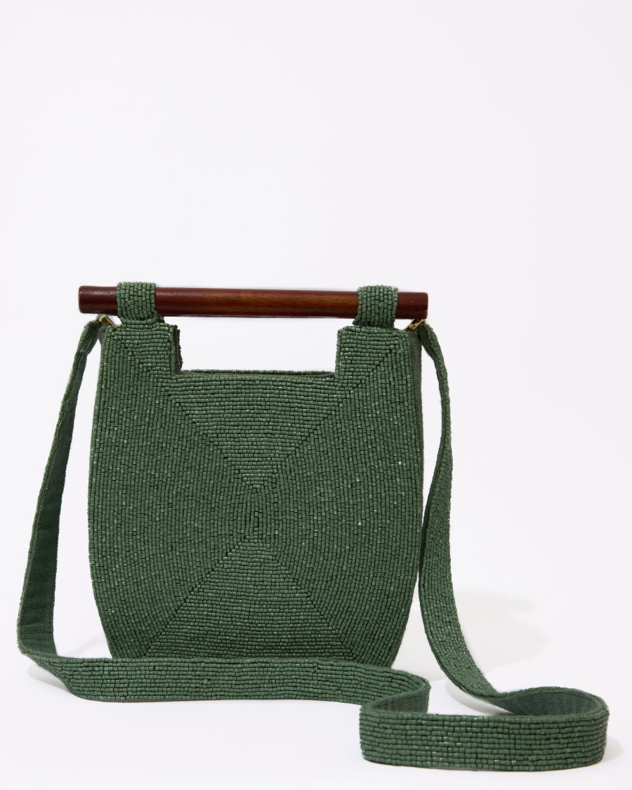 Three-quarter studio view of the Reach for Words jade green beaded bag featuring a sculptural silhouette and dark wooden bar handles.