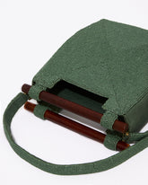 High-angle studio shot looking into the jade green beaded bag, emphasizing the clean architectural lines and wooden handle attachment.