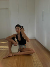 A UGC selfie of a model holding the Reach for Words bag by its wooden handles to demonstrate scale and handheld styling.