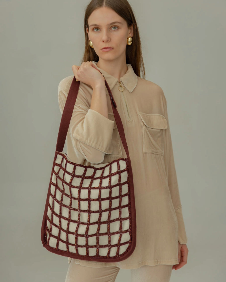 Full body shot of a model carrying the Returning Form tote, highlighting its 34cm height, ideal for carrying a laptop and essentials.