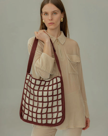 Full body shot of a model carrying the Returning Form tote, highlighting its 34cm height, ideal for carrying a laptop and essentials.