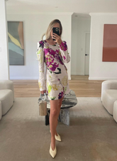 Mirror selfie of a women in a floral dress styling the brass Right Off The Edge bag.
