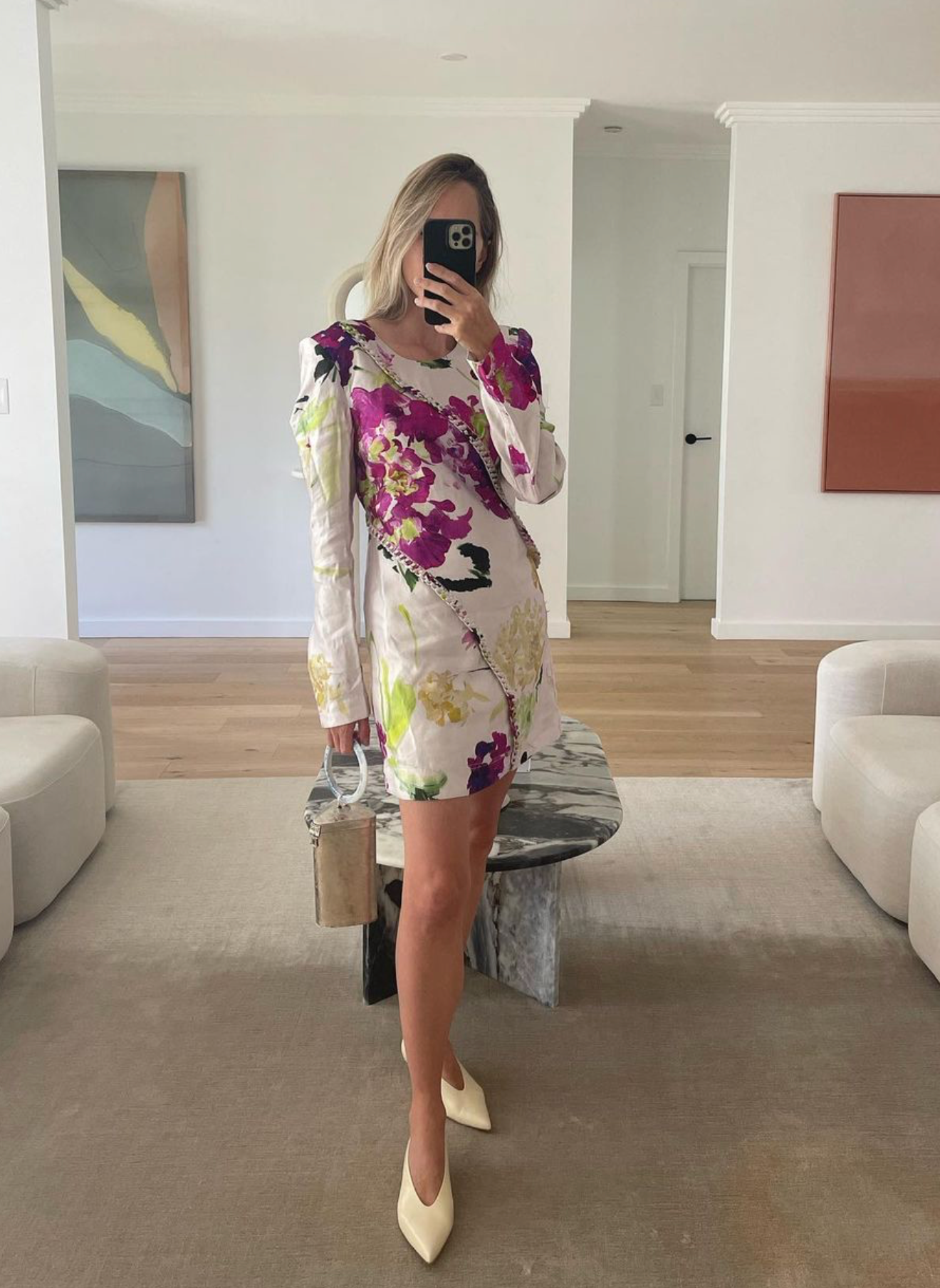 Mirror selfie of a women in a floral dress styling the brass Right Off The Edge bag.