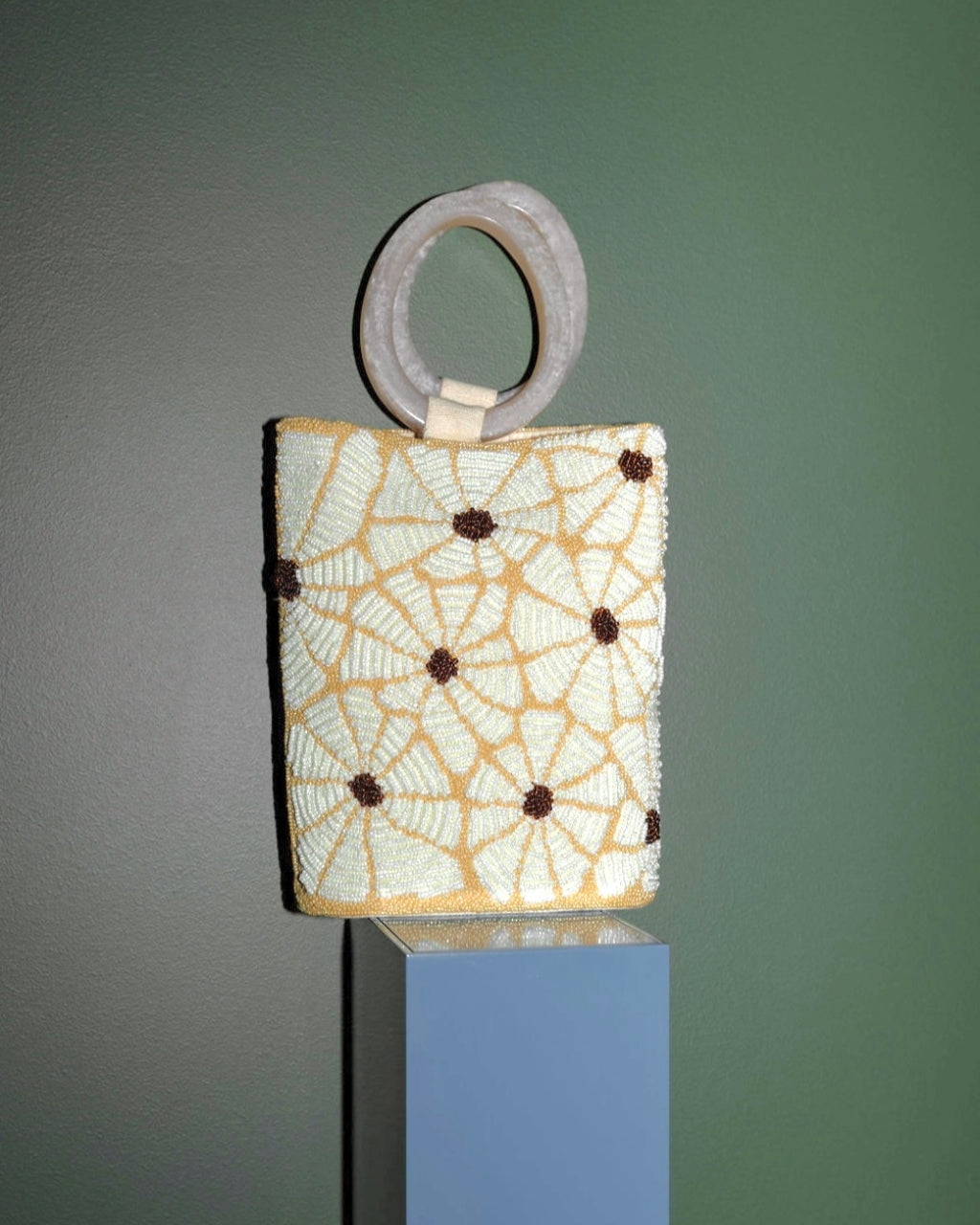 Still Bloom floral beaded bag displayed in a styled interior setting