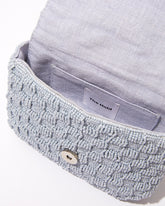 Open view of the Uncovered Layers waist bag showing the natural jute lining and internal magnetic closure for secure storage.