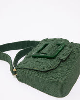 Side view of the jade green beaded bag showing the depth and the detachable matching beaded strap for crossbody styling.