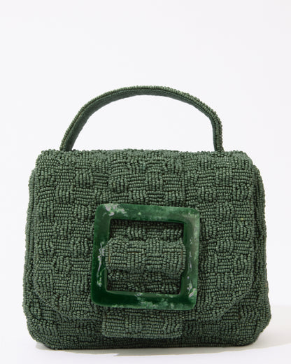 Straight-on studio shot of the jade green Uncovered Layers bag, showing the symmetrical resin buckle and beaded top handle.