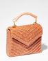 Three-quarter studio view of the artisan-made Waves Never Cease peach beaded handbag with a hand-sewn chevron pattern and jute handle.
